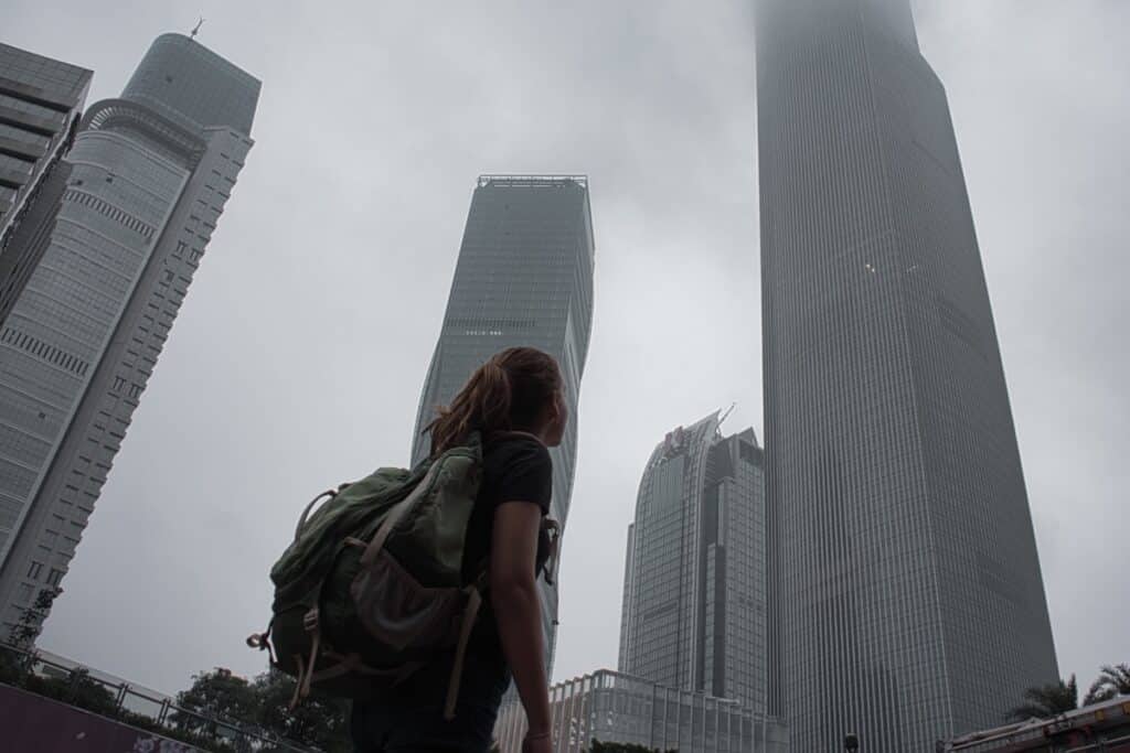 A young woman looks up at a Chinese skyline